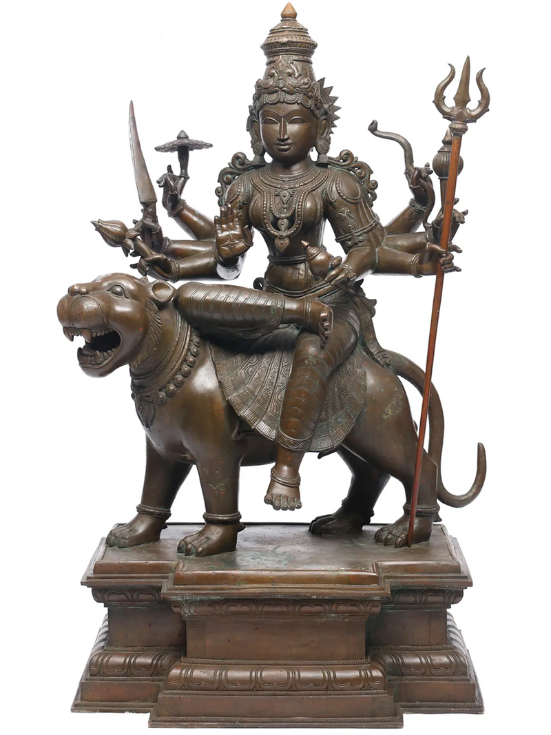 Bronze statue of Durga on a lion with multiple arms holding weapons