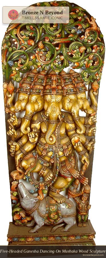 Decorative wall panel with intricate carvings of ganesh and a figure on a pedestal.