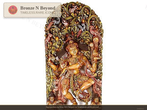 Decorative wall art with a figure holding a lamp, surrounded by intricate designs on a white background.